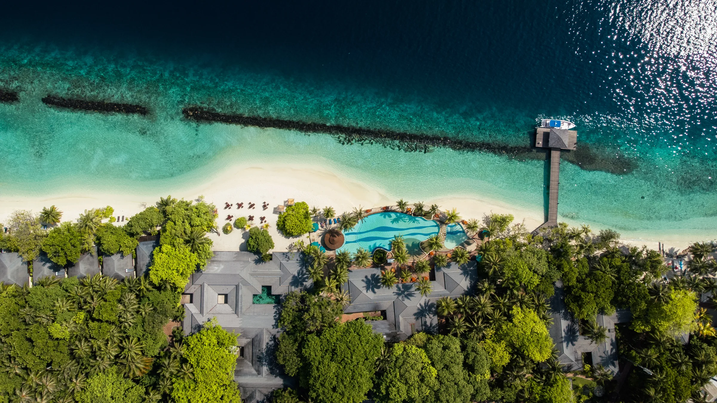 Luftaufnahme eines Inselresorts mit Pool und Strand auf den Malediven